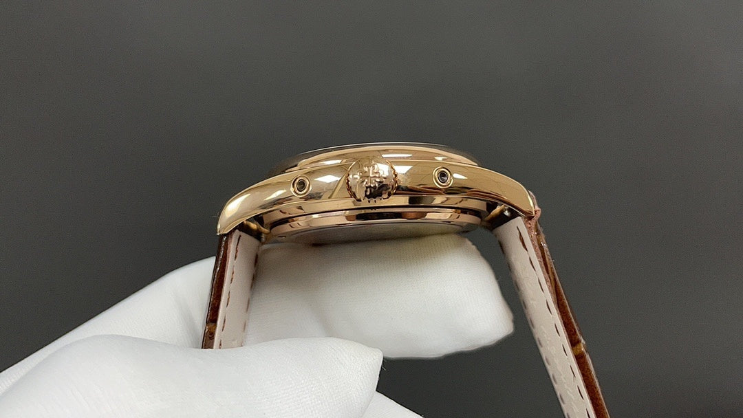 Gold-tone wristwatch case back on brown leather strap