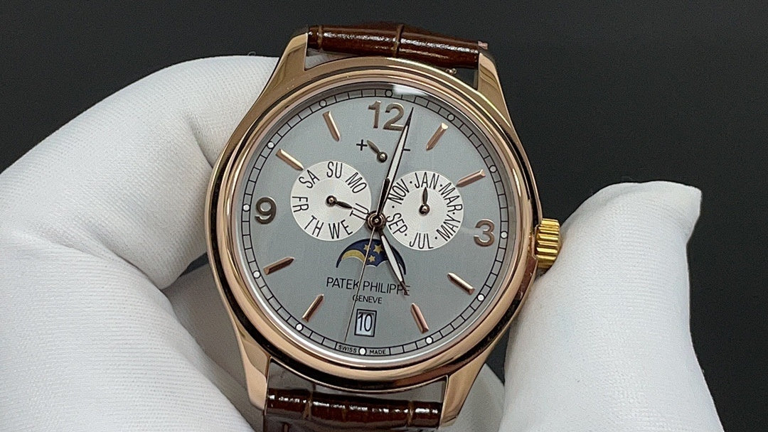 Gold-tone wristwatch with silver dial and brown leather strap, roman numerals