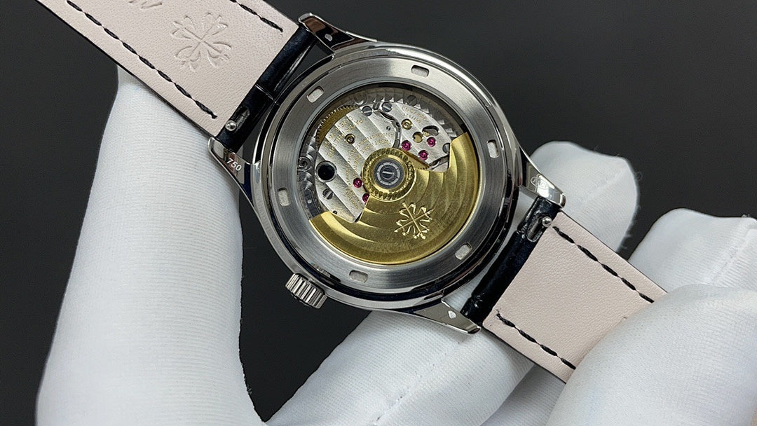 Wristwatch caseback with visible mechanical movement and black leather strap