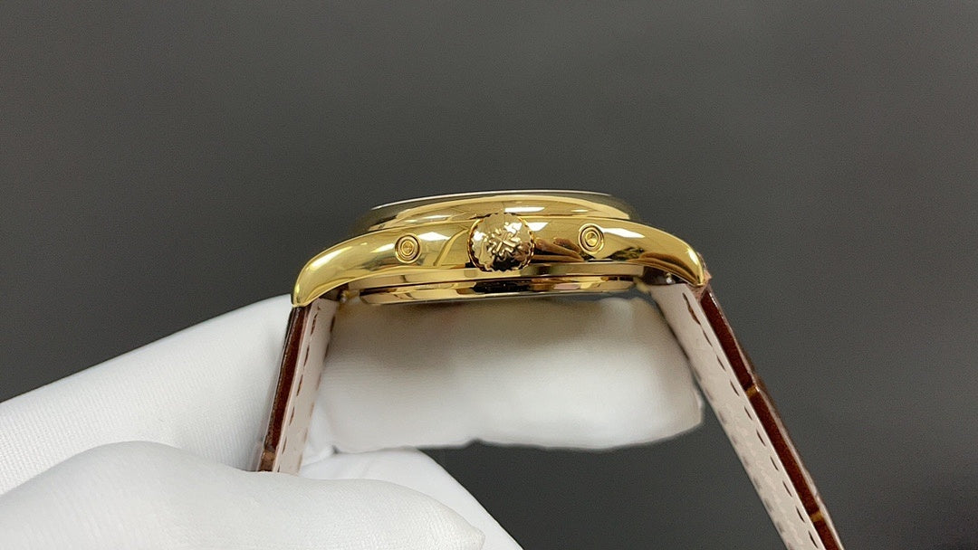 Patek Philippe watch gold case back with brown leather strap on a white glove.