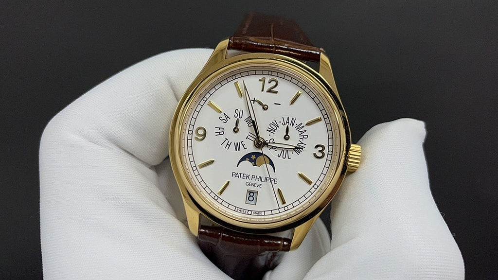 Patek Philippe watch front view, gold case, white dial, and brown leather strap.