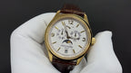 Patek Philippe watch front view, gold case, white dial, and brown leather strap.