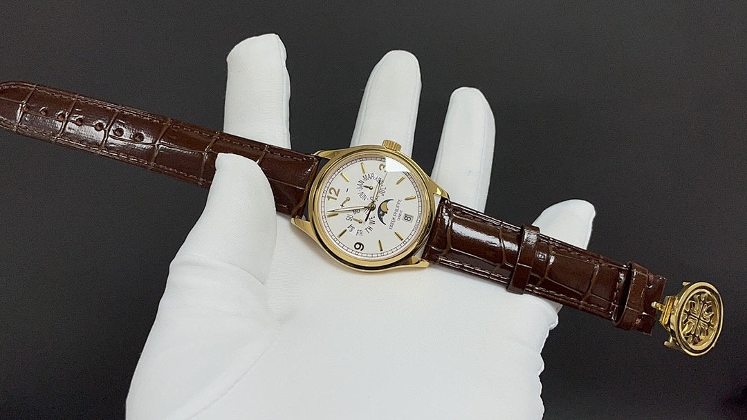 Patek Philippe watch on brown leather strap, gold case, and white dial.