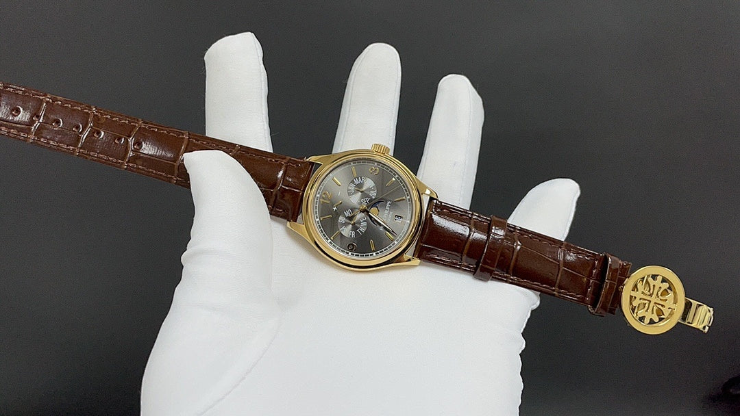 Patek Philippe wristwatch on hand, gold buckle, brown leather strap, round dark dial