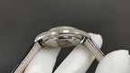 Patek Philippe watch case profile with black leather strap on both sides, polished bezel