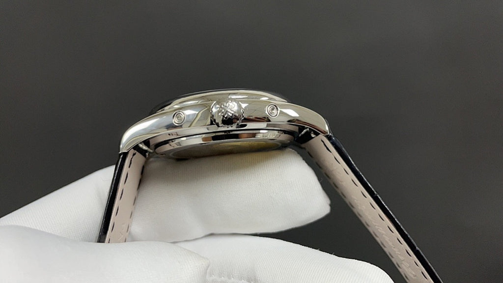 Patek Philippe watch top view of polished case with crown and black leather strap