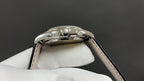 Patek Philippe watch top view of polished case with crown and black leather strap