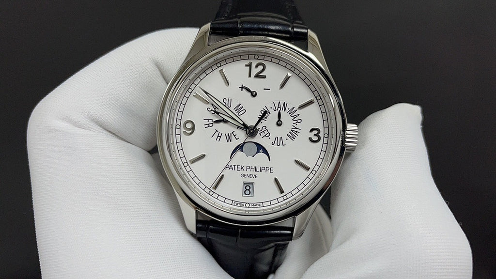 Patek Philippe watch front with white dial, Arabic numerals, black leather strap