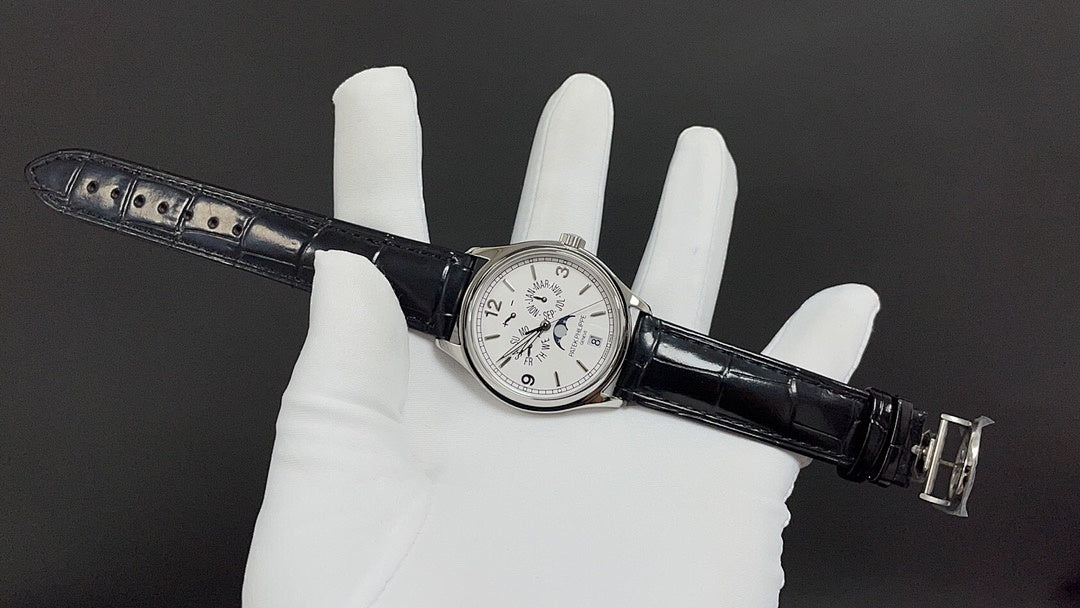 Patek Philippe watch on wrist strap, silver case with white dial and black leather