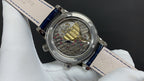 Patek Philippe watch with see-through caseback, visible movement, and blue leather strap