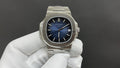 Patek Philippe wristwatch with blue dial, stainless steel bracelet, date window at 3