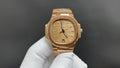 Patek Philippe gold-tone wristwatch with champagne dial and baton markers.