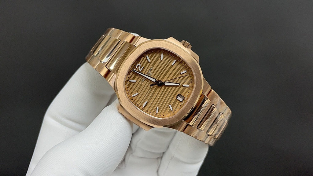 Patek Philippe gold-tone wristwatch with patterned champagne dial and baton hour marks.