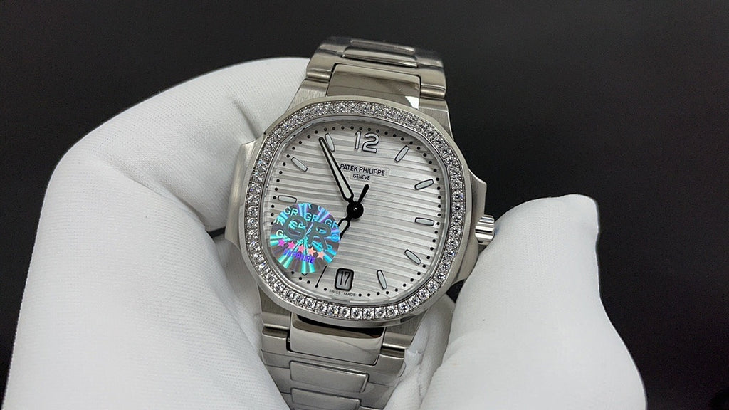 Silver metal wristwatch with white dial, jeweled bezel, and rainbow center