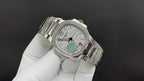 Silver metal wristwatch with white dial and rainbow center, angled side view