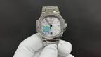 Silver metal wristwatch on a white-gloved hand, white dial and rainbow center motif