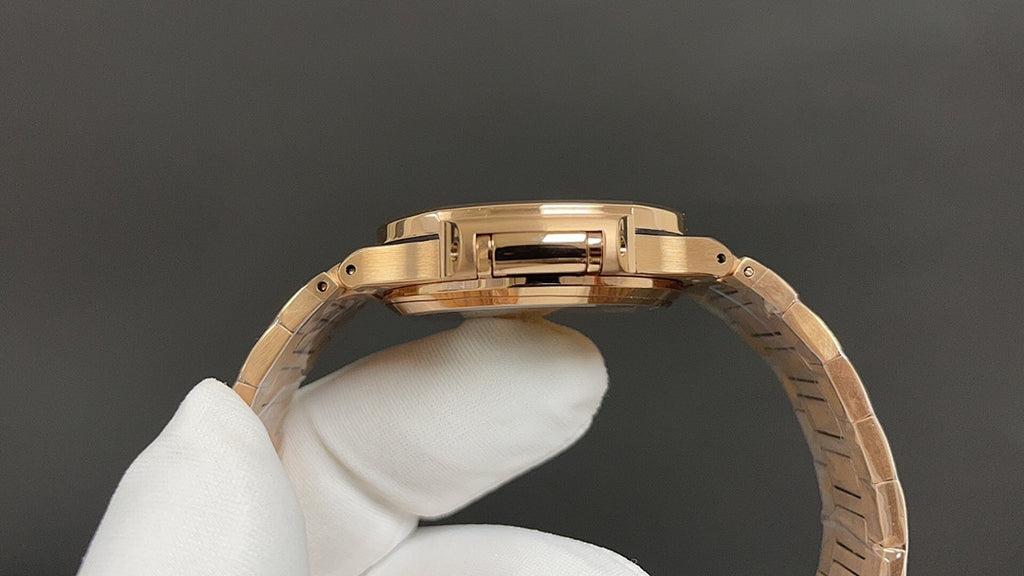 Gold-tone wristwatch case and bracelet side profile on a white glove
