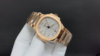 Gold-tone Patek Philippe wristwatch with textured white dial and metal bracelet