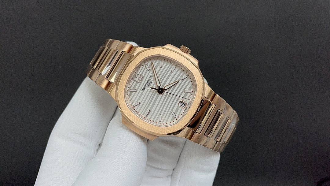 Gold-tone Patek Philippe wristwatch with textured white dial and metal bracelet