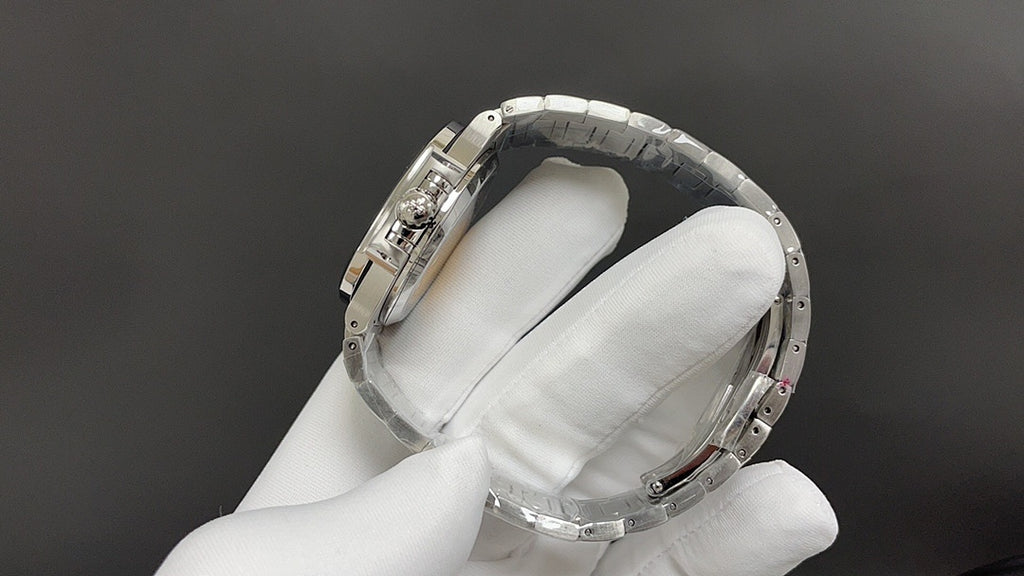 Stainless steel bracelet and case back, held in white-gloved hand