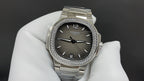 Stainless steel wristwatch with dark dial, diamond-studded bezel, metal bracelet