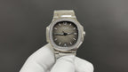 Round stainless steel wristwatch with dark dial and jeweled bezel on metal bracelet