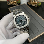 Stainless steel Patek Philippe watch with black dial, teal accents, and integrated bracelet