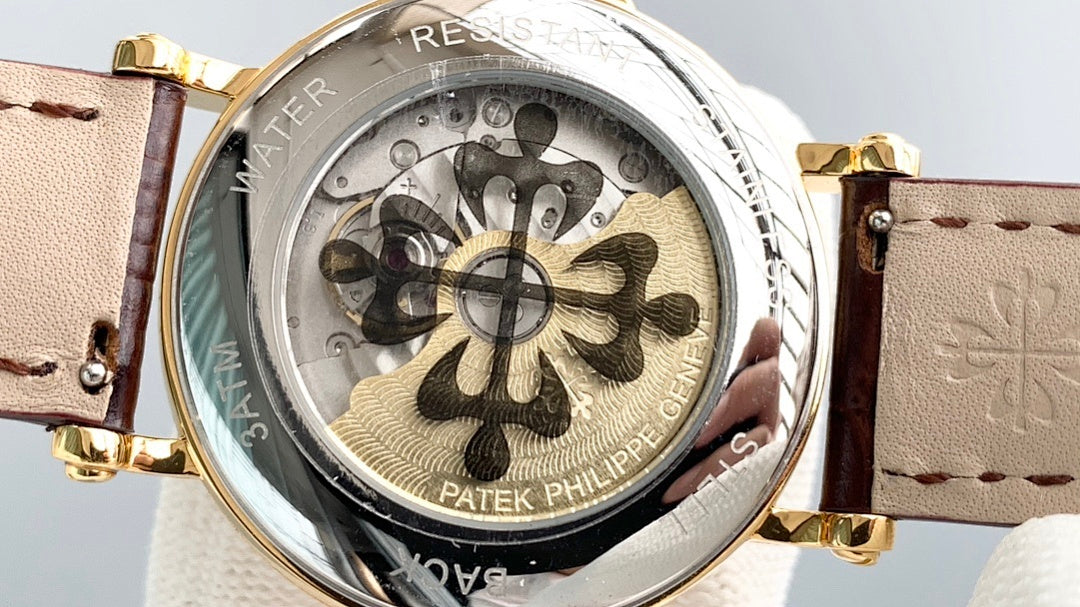 Patek Philippe watch caseback close-up with engraved floral pattern and brown leather strap