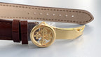 Brown leather strap with round gold clasp and engraved center medallion