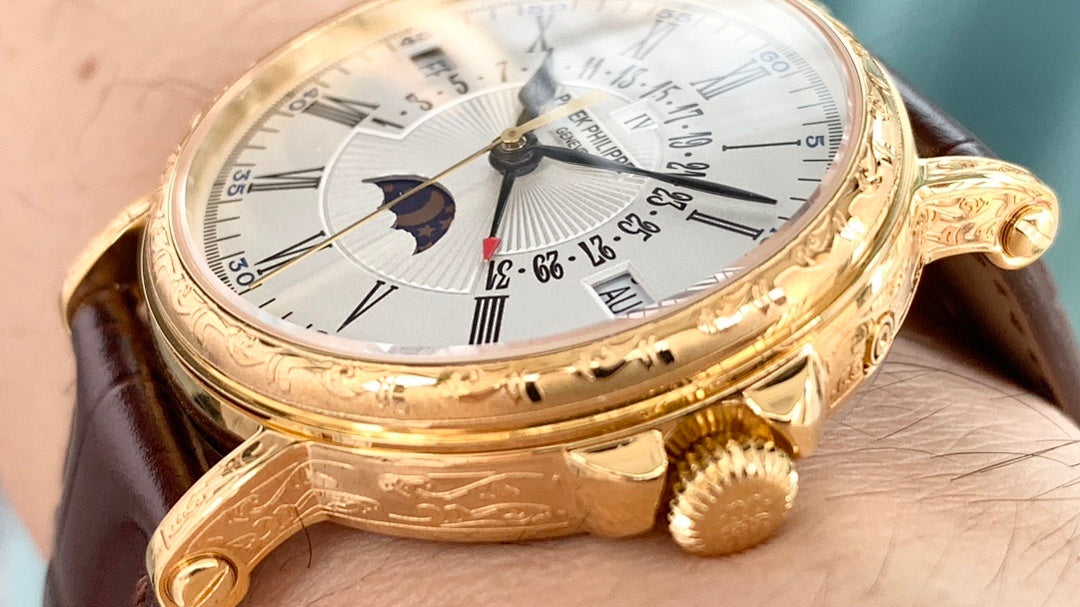 Gold wristwatch close-up on wrist, white dial with subdials and moonphase