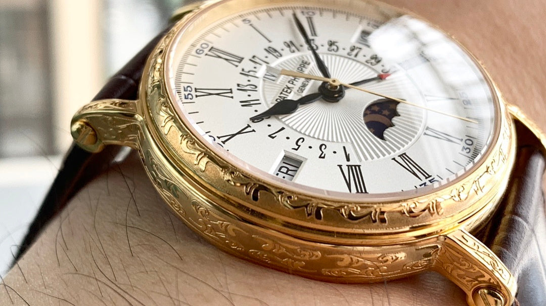 Gold wristwatch on wrist, white dial with Roman numerals and moonphase