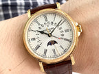 Gold wristwatch with brown leather strap on forearm, white dial with Roman numerals