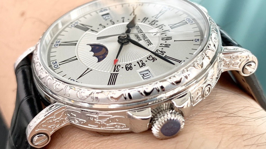 Luxury wristwatch side view with black leather strap, crown, and engraved bezel