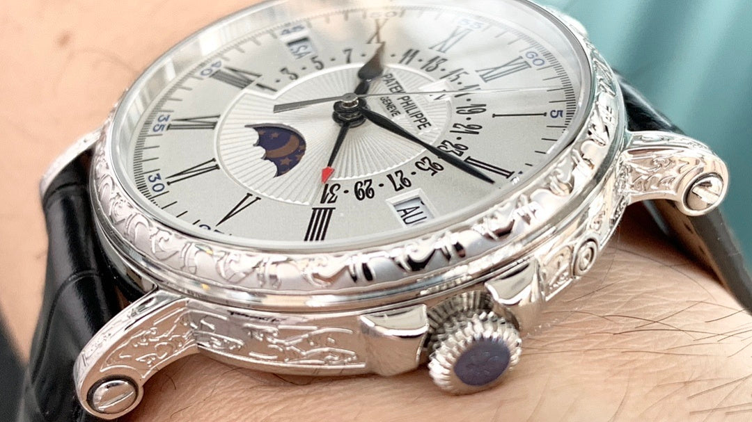 Luxury wristwatch side view with black leather strap, crown, and engraved bezel