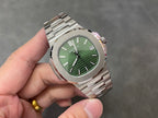 Wristwatch with green dial, baton markers, and date window at 15 on steel case