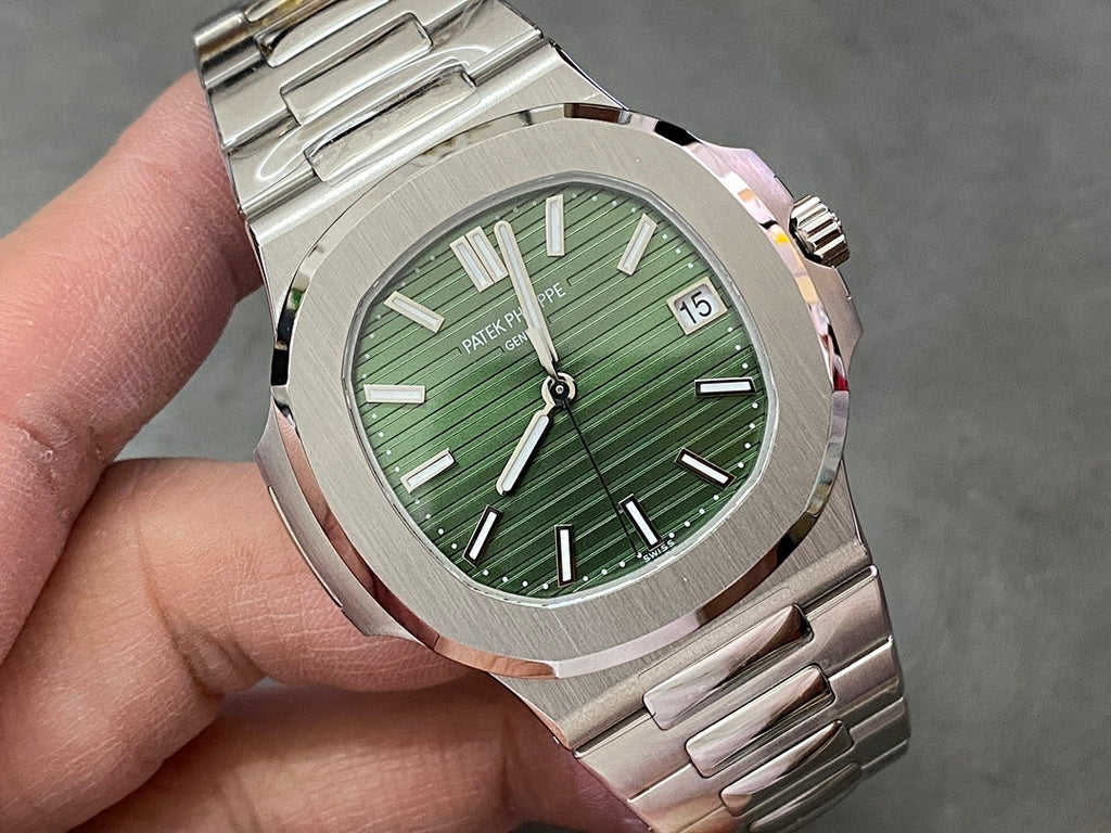 Wristwatch close-up with green dial, baton markers, and date window at 15
