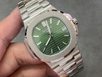 Wristwatch close-up with green dial, baton markers, and date window at 15