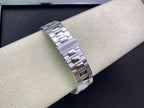 Stainless steel watch bracelet on wrist, featuring polished and brushed link segments