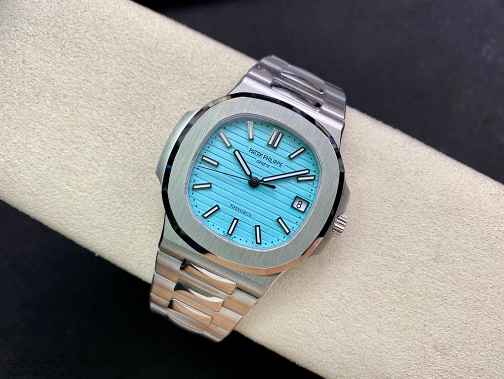 Stainless steel wristwatch with bright blue dial and polished bezel, angled view on wrist