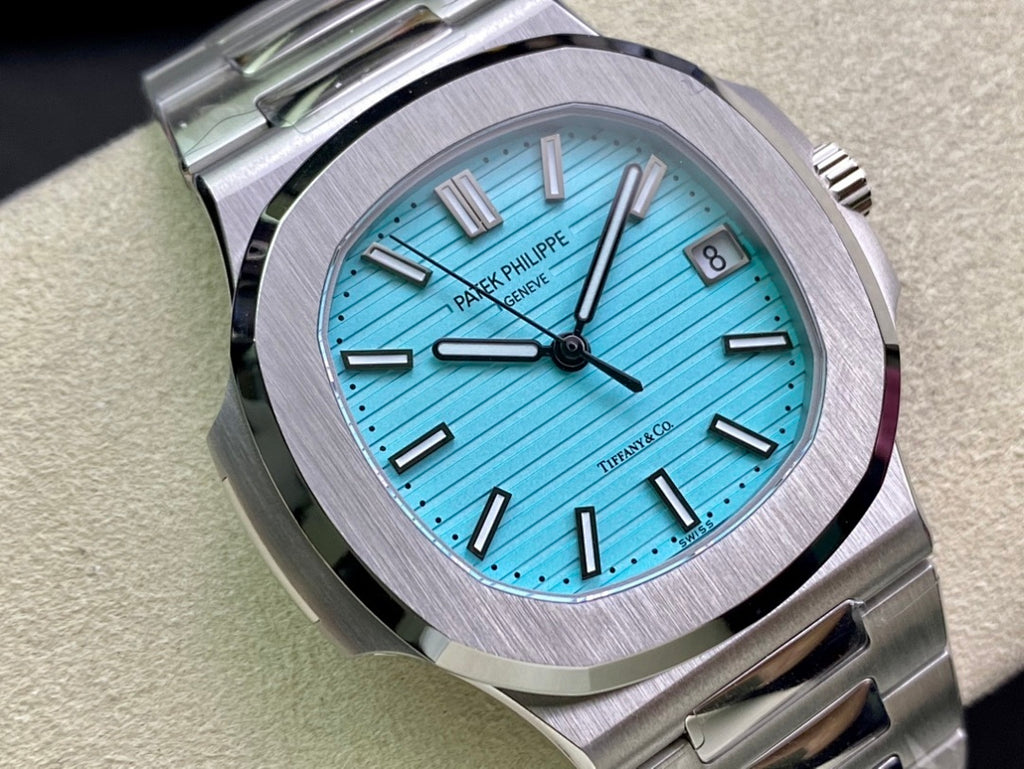 Stainless steel watch face with bright blue dial, baton hour markers, and date window