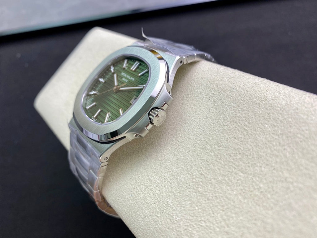 Patek Philippe watch with green dial and silver bracelet, angled view on display