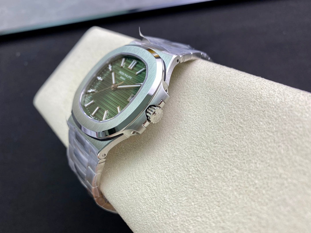 Patek Philippe watch with green dial and silver bracelet, angled view on display