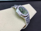 Patek Philippe watch with green dial, silver case and bracelet, angled view on display
