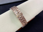 Rose-gold metal bracelet with clasp links on watch display