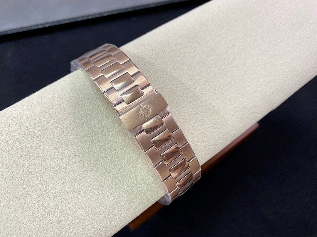 Rose-gold metal bracelet with clasp links on watch display