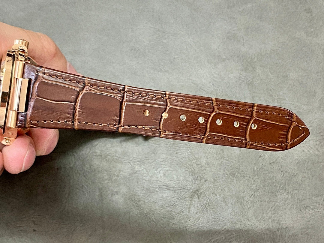 Brown leather watch strap with gold-tone buckle and stitched edge