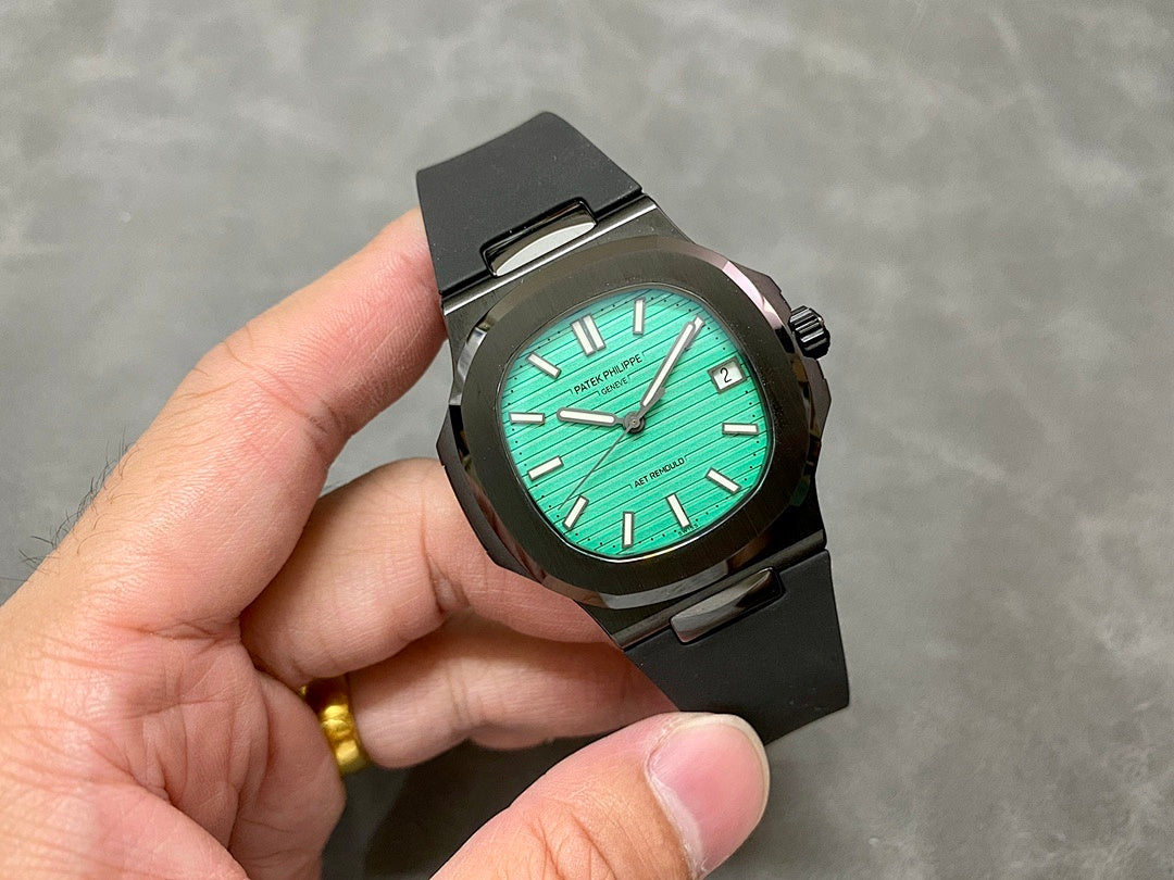 Black wristwatch with turquoise dial, baton markers, and date window at 3 o’clock
