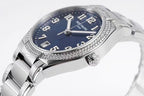 Stainless steel watch with blue dial, diamond bezel, and crown detail