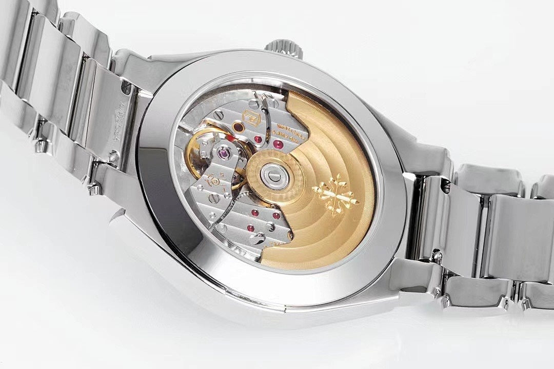 Steel wristwatch close-up showing internal movement through open dial window and bracelet