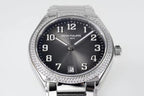 Diamond bezel steel wristwatch with dark dial, date window, and crown at 3 o'clock